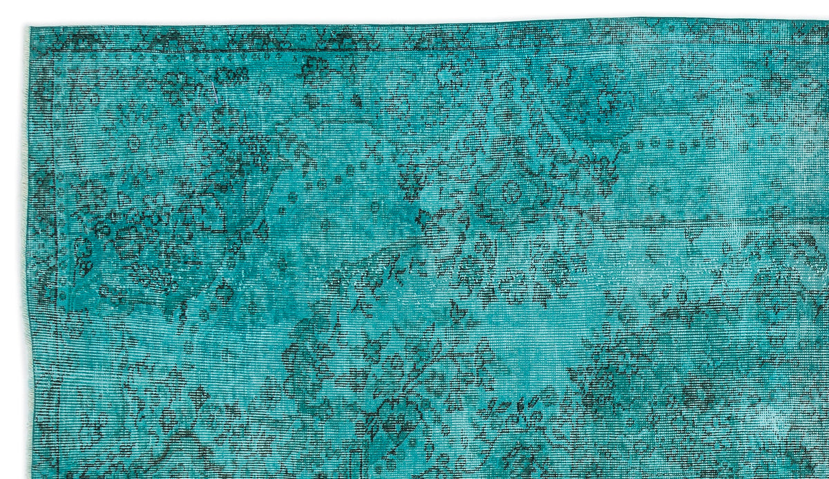 Teal and black distressed rug with a faded traditional floral medallion pattern.