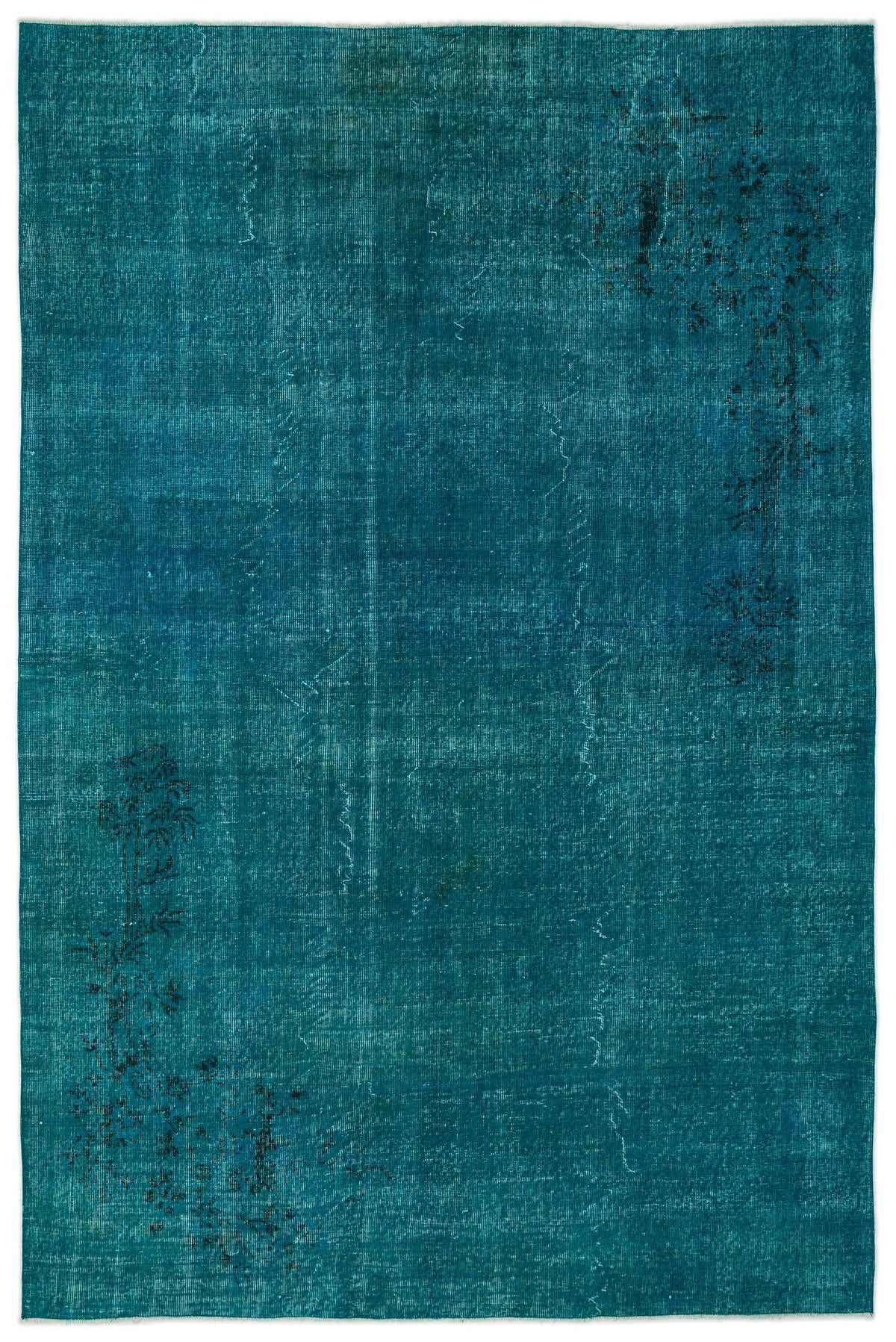 Teal distressed rug with a faded, monochromatic finish and subtle black floral motifs in opposite corners.