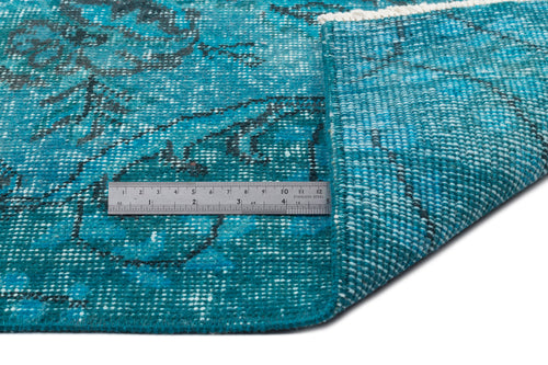 Load image 1 in gallery view. Teal and black distressed floral rug with a folded corner and a stainless steel ruler for scale.
