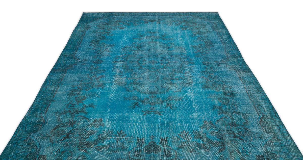 Distressed turquoise and black traditional medallion rug with a faded, vintage-style floral pattern.