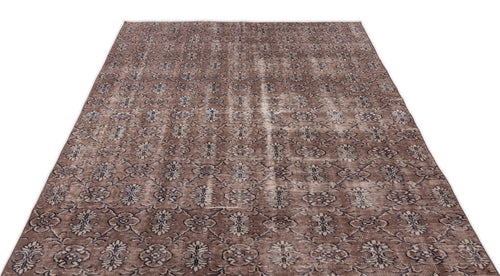 Load image 1 in gallery view. Brown and dark blue distressed rug with an all-over repeating floral medallion pattern on a white background.