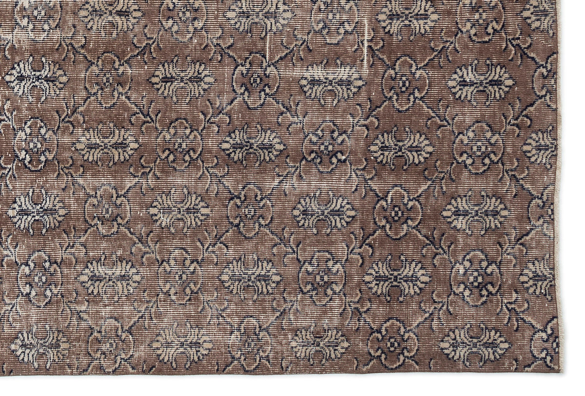 Brown and charcoal grey vintage-style rug with a repeating floral medallion pattern on a white background.