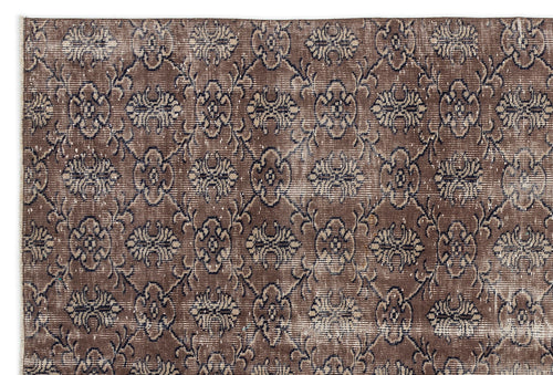 Load image 1 in gallery view. Brown and charcoal distressed rug with a repeating floral medallion pattern in a lattice grid.