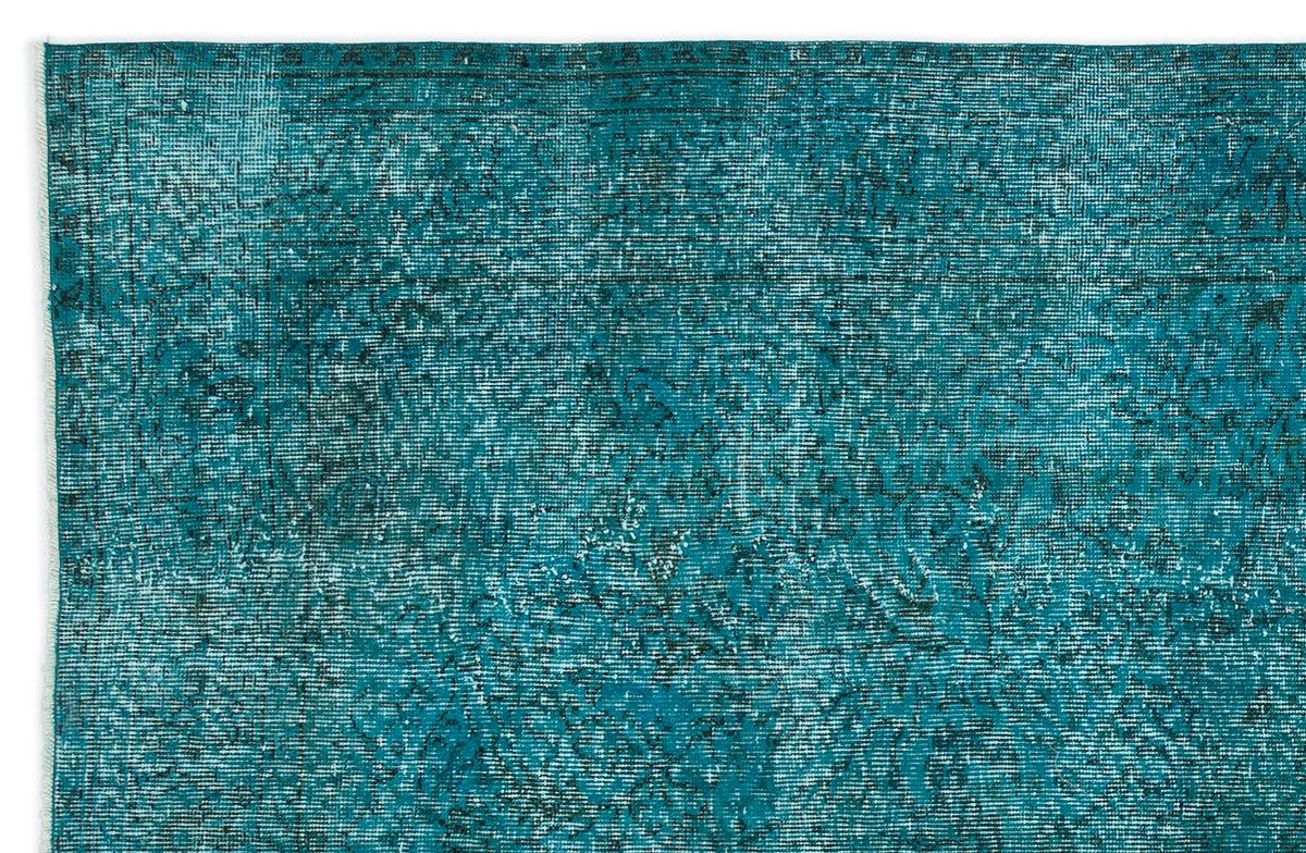 Teal and black distressed vintage-style rug with a faded traditional floral pattern.