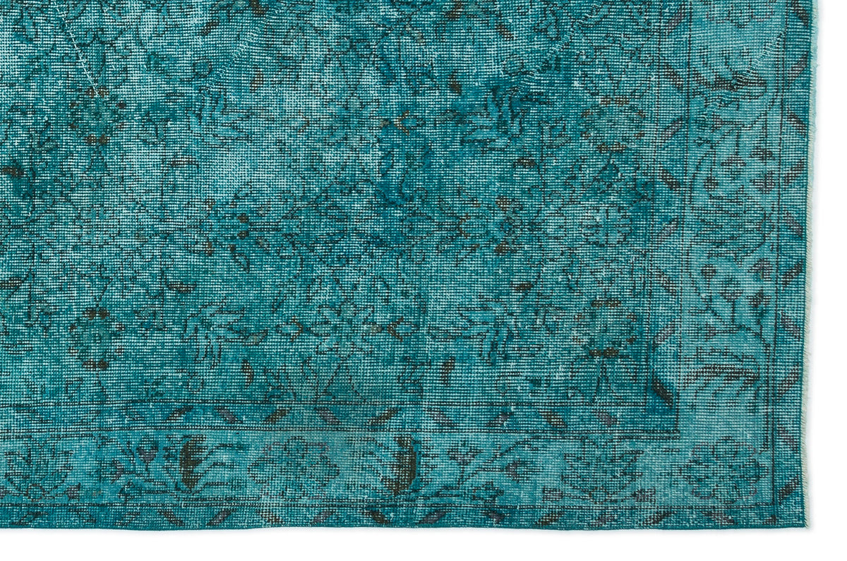 Teal distressed rug with a dark grey traditional floral pattern and a bordered edge.