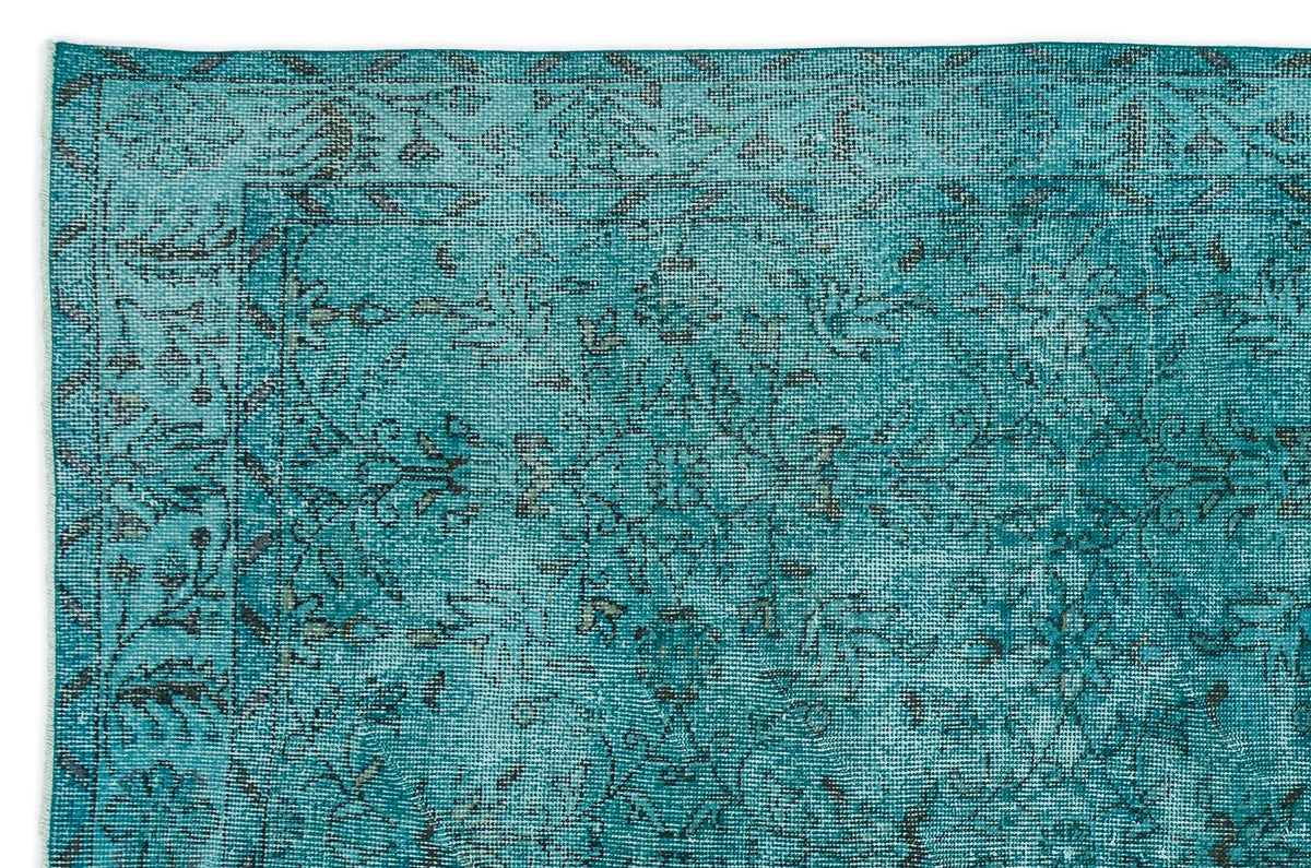 Teal and black distressed rug with a traditional floral medallion pattern and a bordered edge.