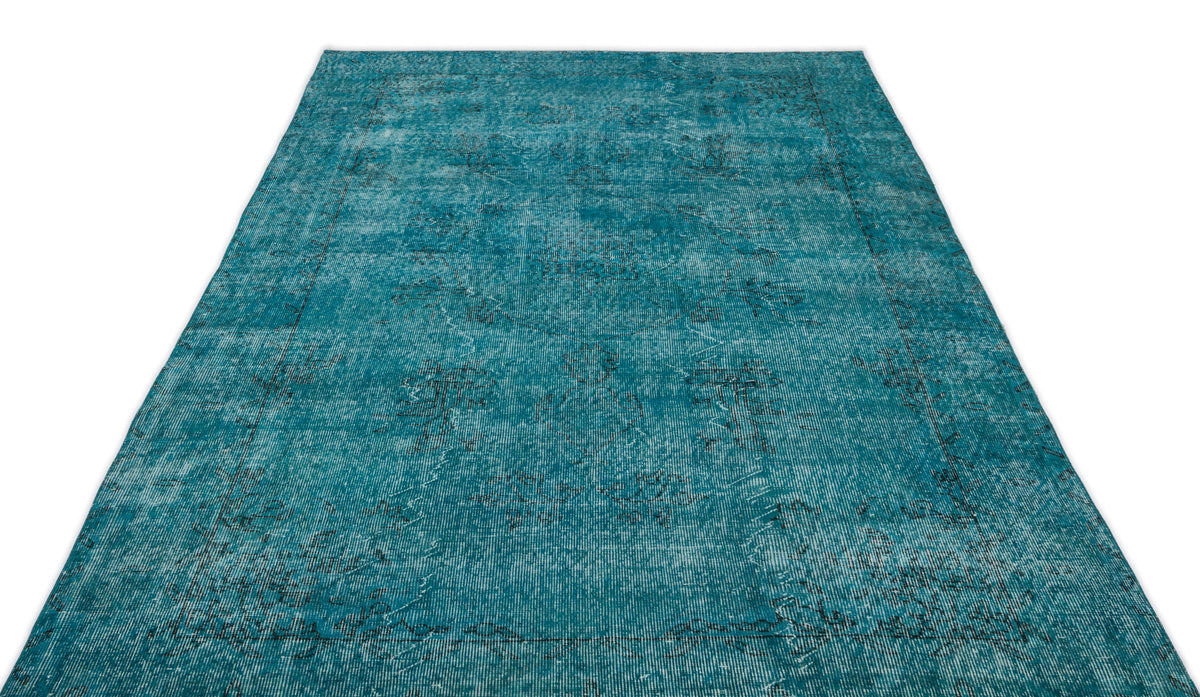 Teal distressed area rug with a faded traditional medallion pattern on a white background.