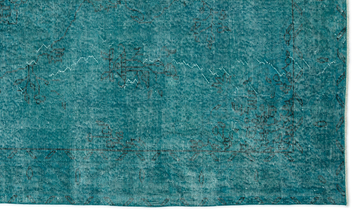 Teal distressed rug with a faded black traditional floral pattern and a thin border on a white background.