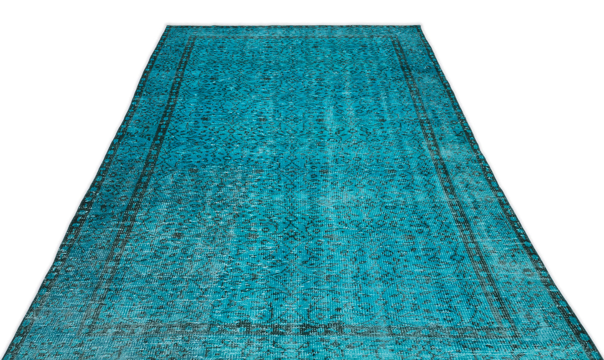 Turquoise and black distressed rug with a traditional ornate medallion pattern on a white background.
