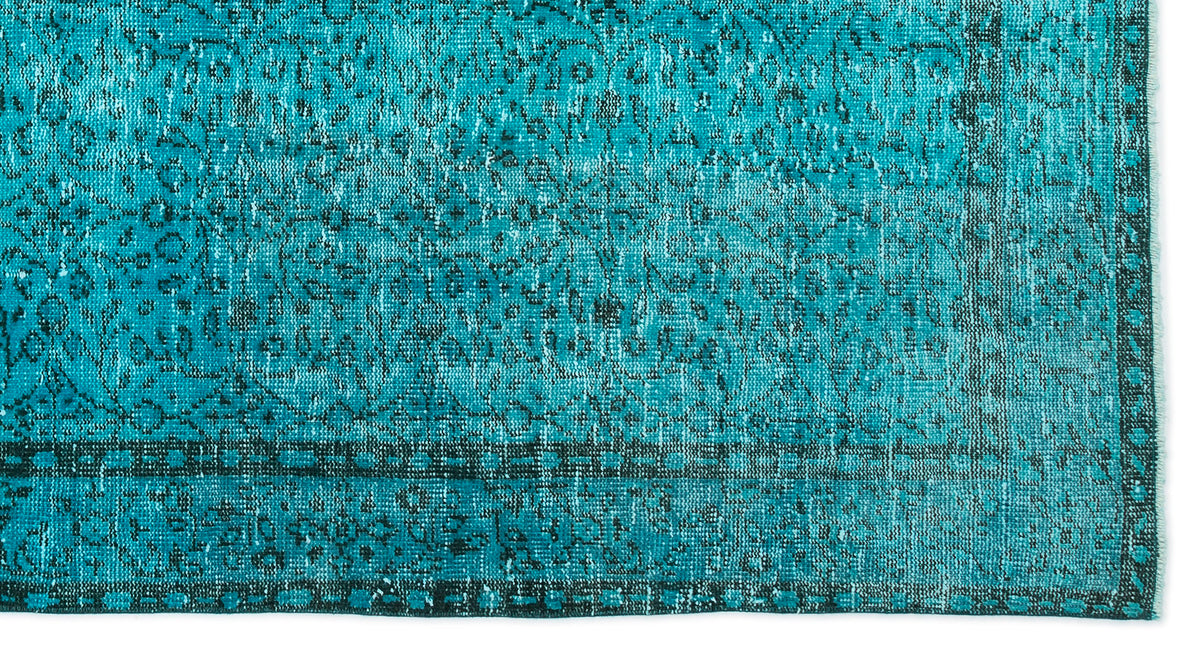 Teal and black distressed rug with a traditional ornate medallion pattern and a geometric border.