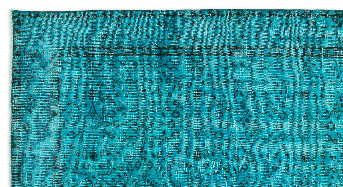 Teal and black distressed rug with a traditional floral medallion pattern and a geometric border.