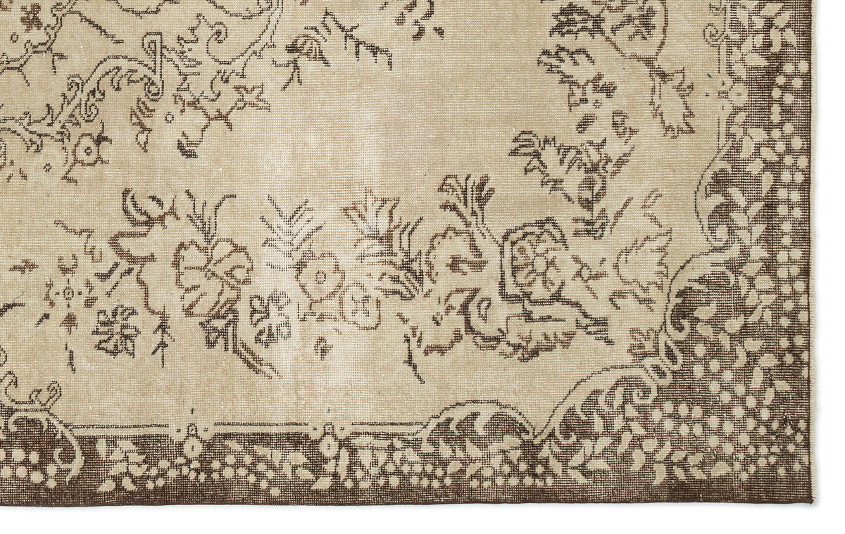 A close-up of the Tiduex Vintage Medallion Rug (6'3" x 9'11") in beige, featuring an ornate brown floral and vine border with decorative flowers, leaves, and swirls.