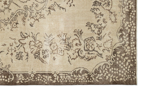 Load image 1 in gallery view. A close-up of the Tiduex Vintage Medallion Rug (6'3" x 9'11") in beige, featuring an ornate brown floral and vine border with decorative flowers, leaves, and swirls.