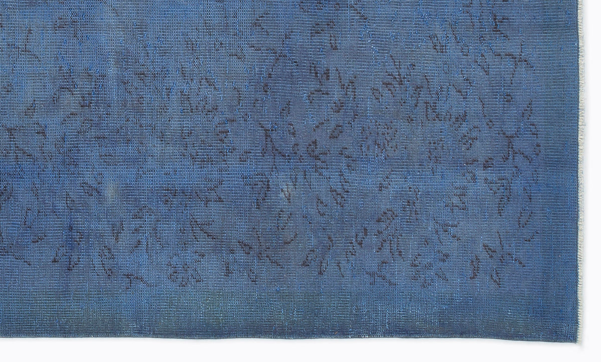 Monochromatic blue rug with a subtle, distressed floral pattern and a short fringe edge.