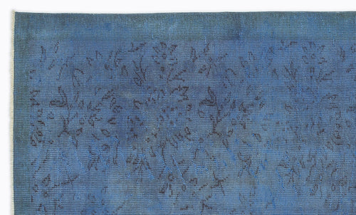 Load image 1 in gallery view. Deep blue vintage-style rug with a faded, dark floral pattern and visible fringe edge.