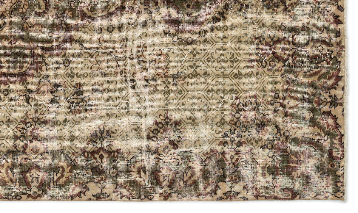 Distressed beige, olive green, and burgundy rug with a traditional floral medallion and geometric pattern.