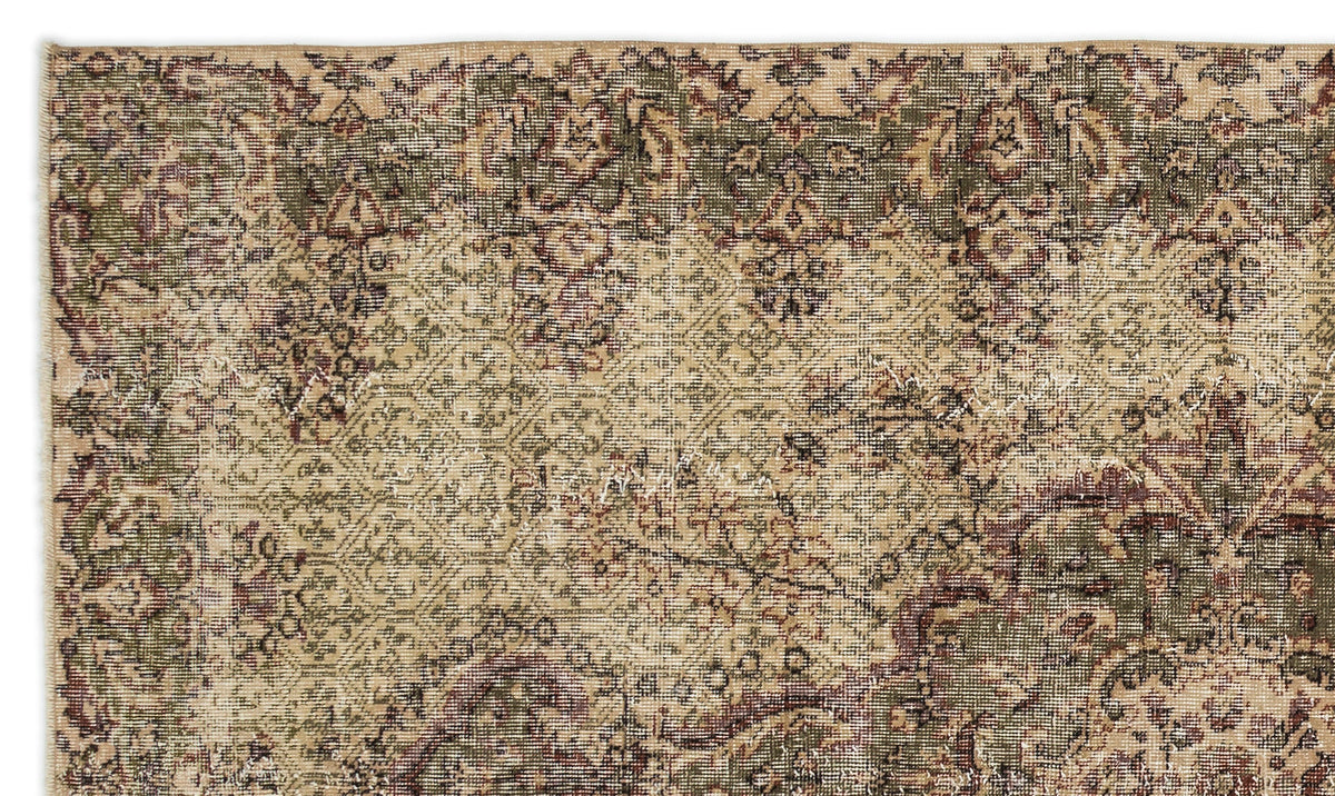 Distressed vintage-style rug with a faded floral medallion pattern in olive green, deep red, and beige.