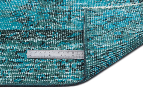 Load image 1 in gallery view. Teal and black distressed-pattern rug with a folded corner and a metal ruler for scale on a white background.