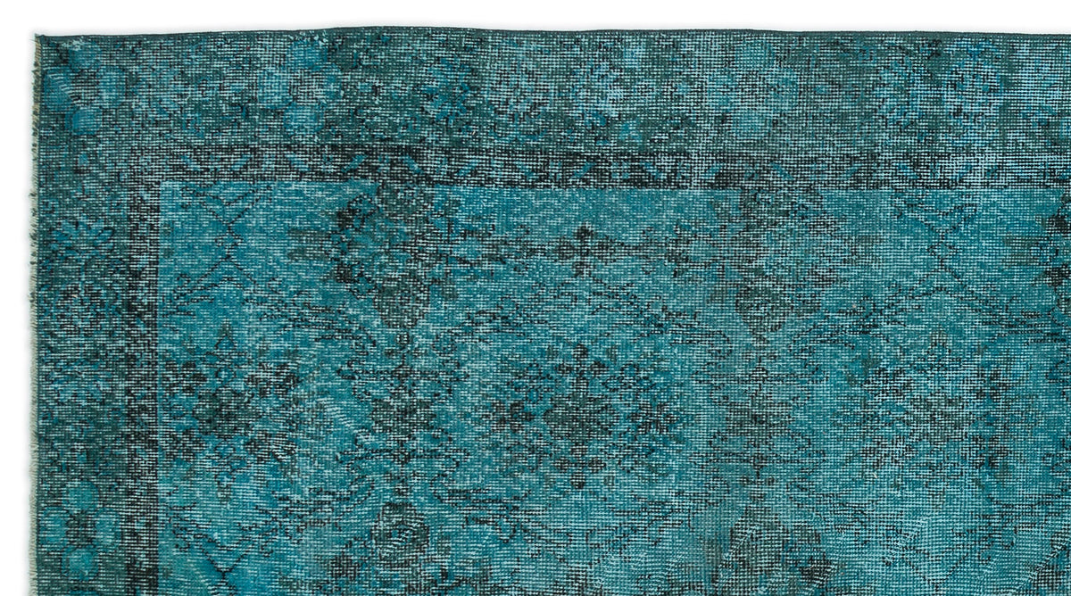 Teal and black distressed rug with a traditional medallion pattern and a wide decorative border.