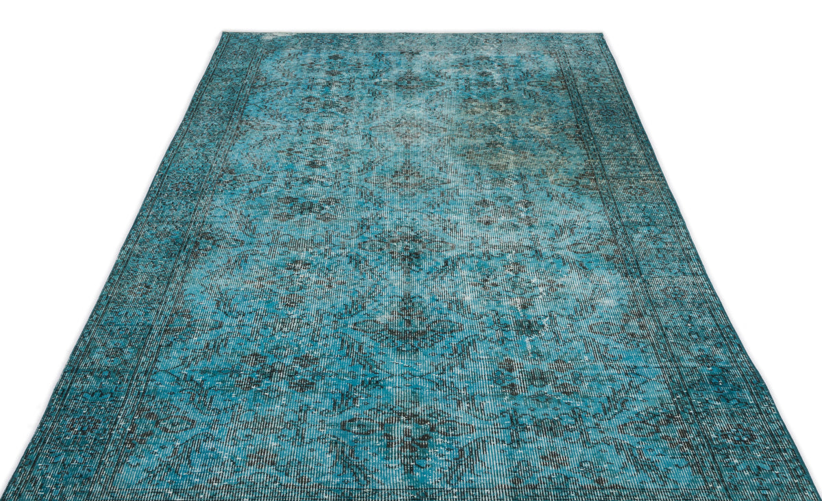 Distressed turquoise and black area rug with a traditional medallion pattern on a white background.