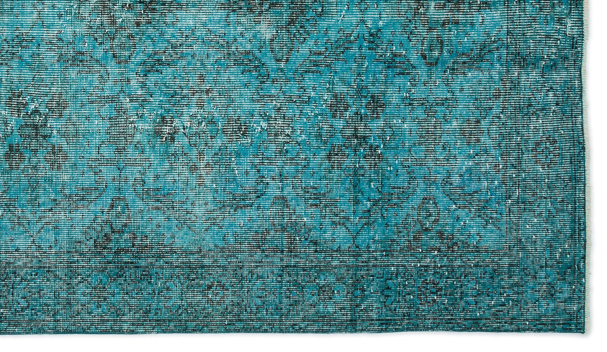 Teal and black distressed rug with a traditional floral medallion pattern and a bordered edge.