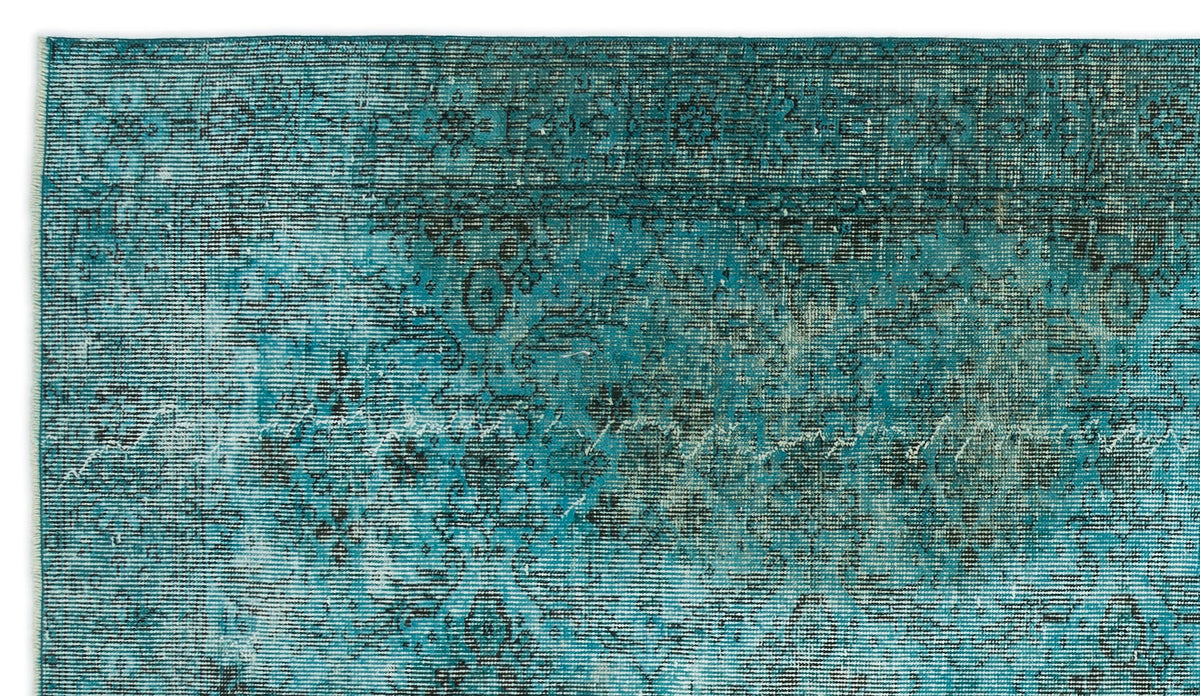 Teal and black distressed rug with a faded traditional floral medallion pattern.