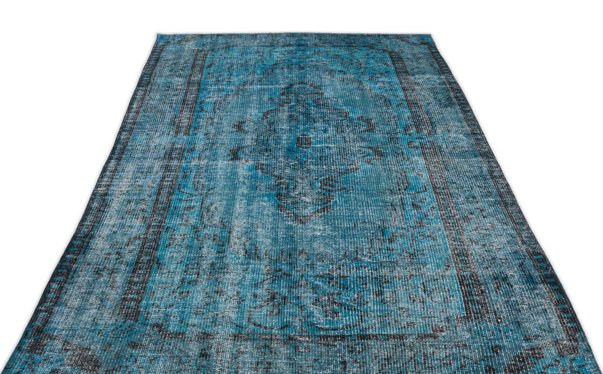 Distressed teal and black area rug with a traditional central medallion and ornate border pattern on a white background.