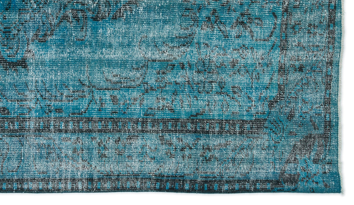 Teal and black distressed rug with a traditional ornate medallion pattern and a bordered edge.