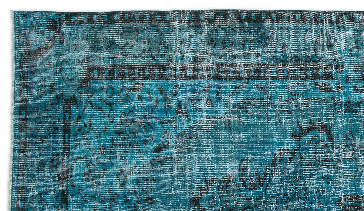 Teal and black distressed traditional rug with a faded floral medallion pattern and a geometric border.