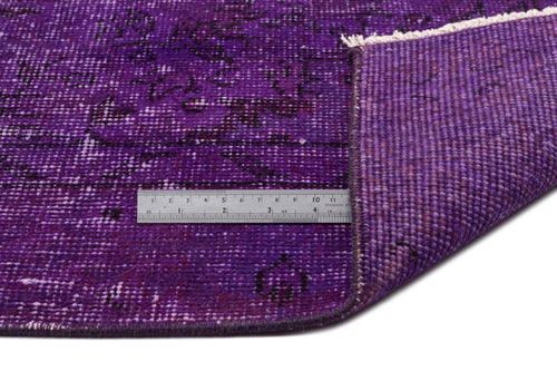 Load image 1 in gallery view. Deep purple distressed rug with a black faded pattern, shown with a metal ruler for scale and a folded corner.