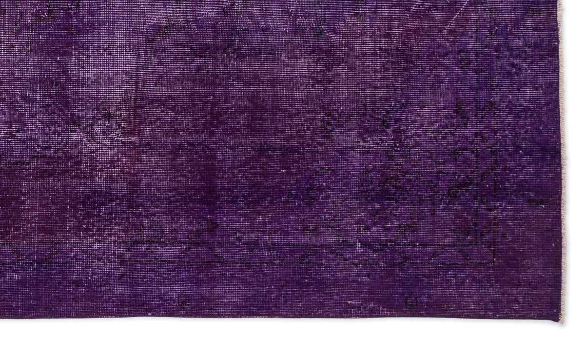 Deep purple distressed rug with a faint, traditional overdyed medallion pattern and a thin border.