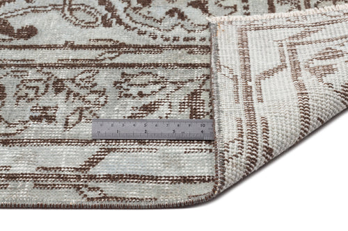 Load image 1 in gallery view. Light blue and brown distressed traditional rug with a folded corner and a metal ruler for scale.