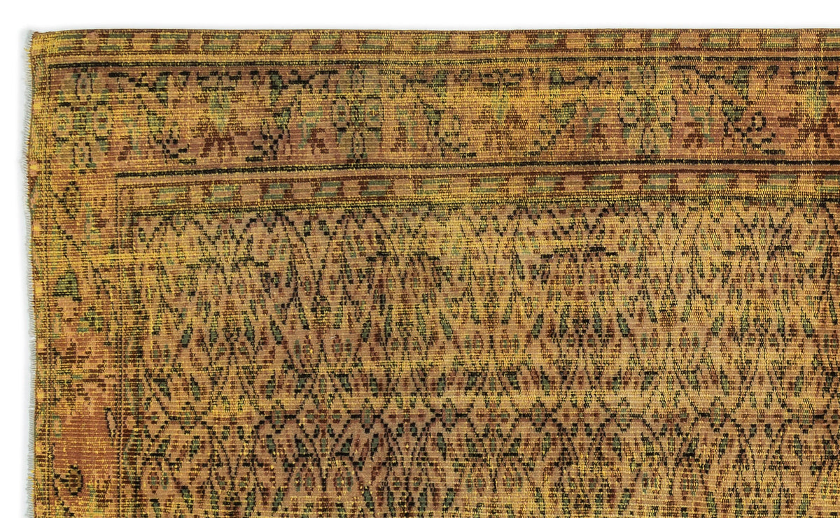 Mustard yellow and brown traditional rug with a repeating geometric diamond pattern and a decorative border.
