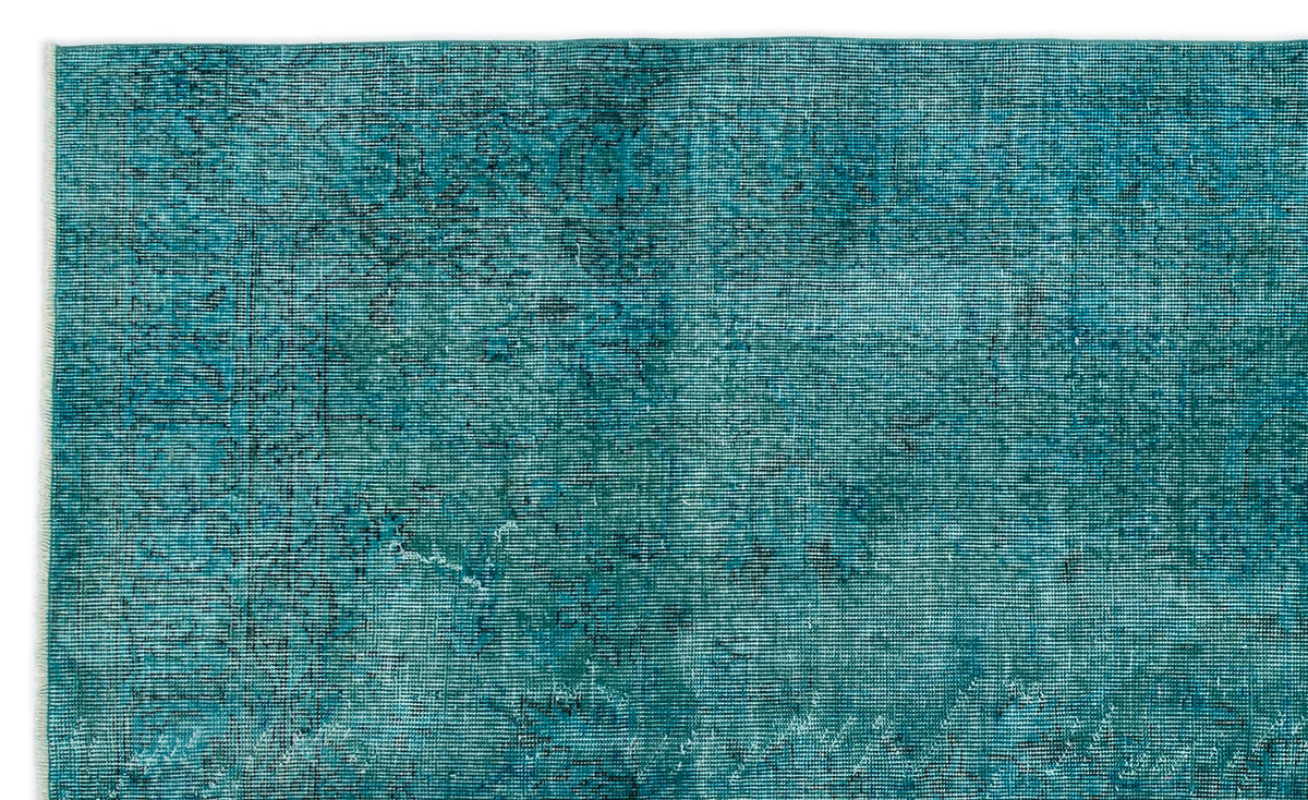 Teal and dark blue distressed rug with a faded, overdyed traditional pattern.