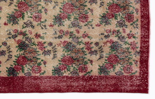 Load image 1 in gallery view. Beige rug with a distressed floral pattern in red, green, and dark grey, featuring a solid red border.