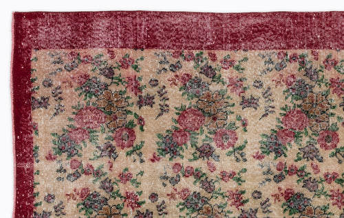 Load image 1 in gallery view. Distressed beige rug with a red border and a repeating floral pattern in shades of red, green, and dark brown.