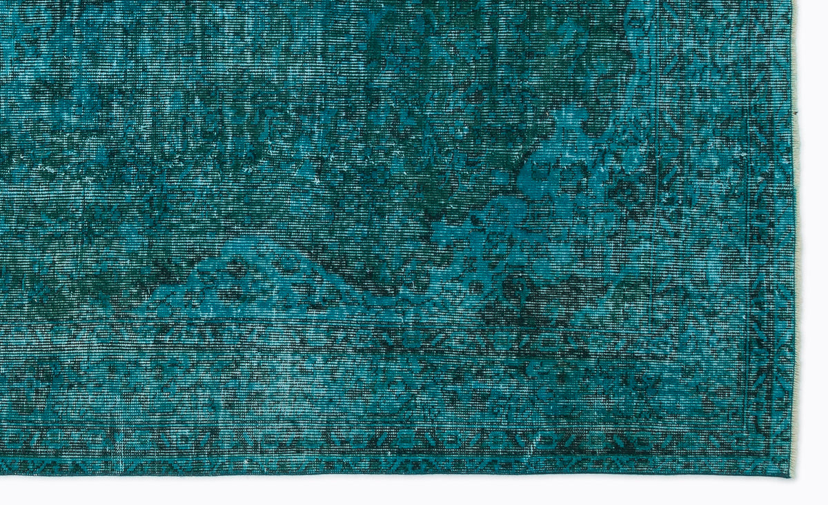 Teal and dark green distressed rug with a faded traditional medallion pattern and a bordered edge.