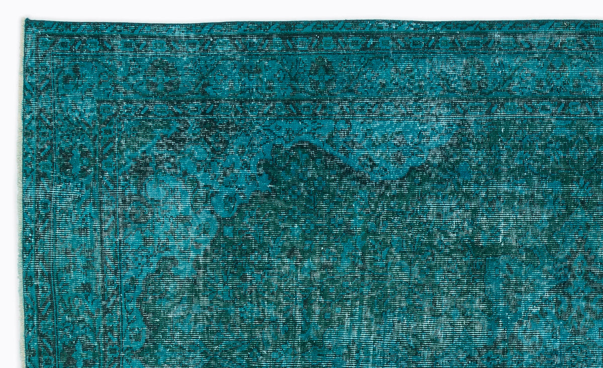 Teal and dark green distressed traditional rug with a faded ornate border and central medallion pattern.