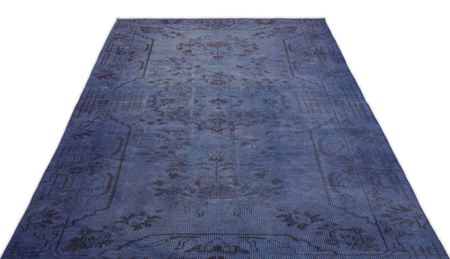 Load image 1 in gallery view. Deep blue distressed rug with a faded traditional floral medallion pattern on a white background.