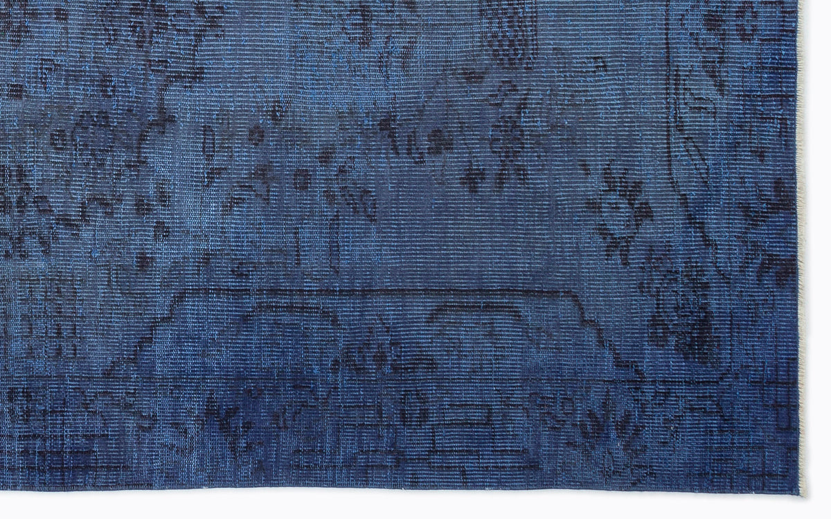 Deep blue vintage-style rug with a faded, dark charcoal traditional floral medallion pattern.