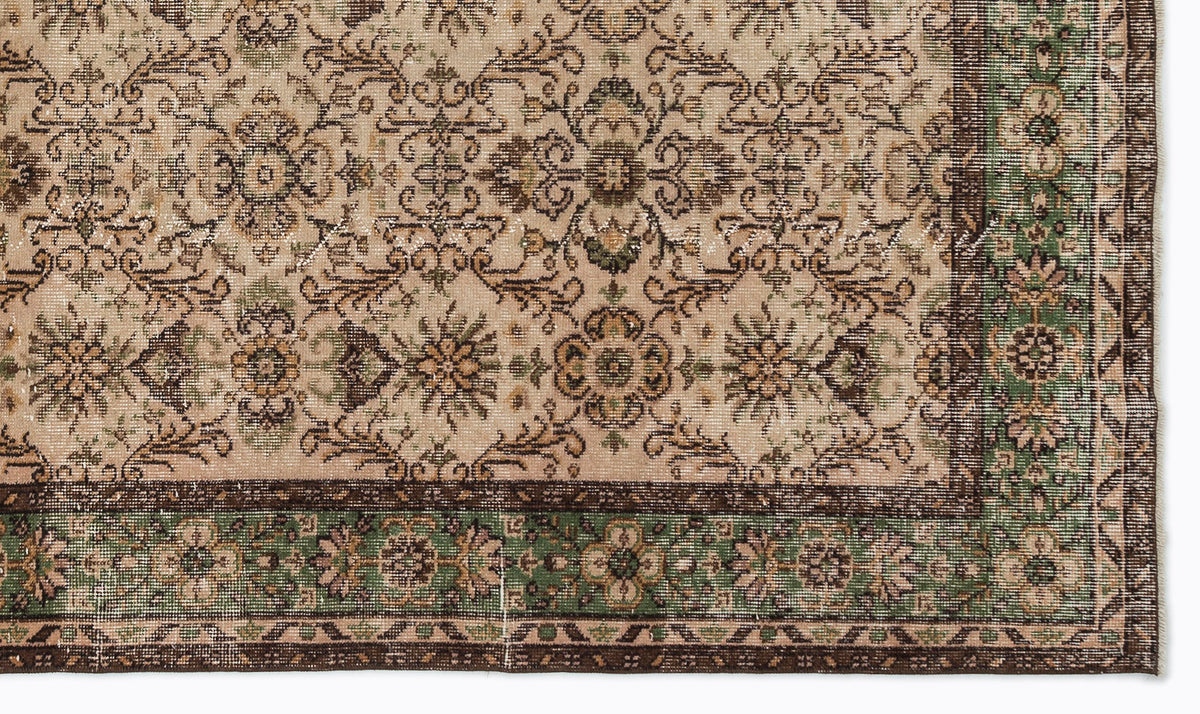 Beige, brown, and green traditional rug with a distressed floral medallion pattern and a decorative border.