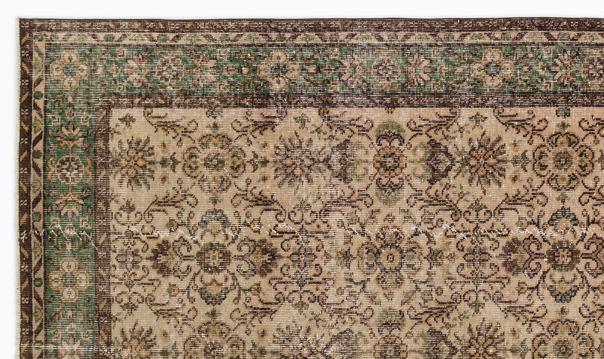 Beige, brown, and green traditional rug with a distressed floral medallion pattern and a decorative border.