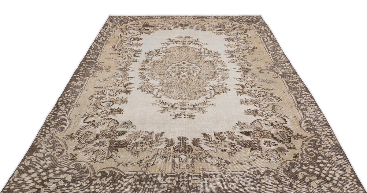 The Hakeon Vintage Medallion Rug (6'5" x 9'8") features intricate floral and vine patterns in beige, brown, and cream with a large medallion and ornate border. Shown photographed on a white background.