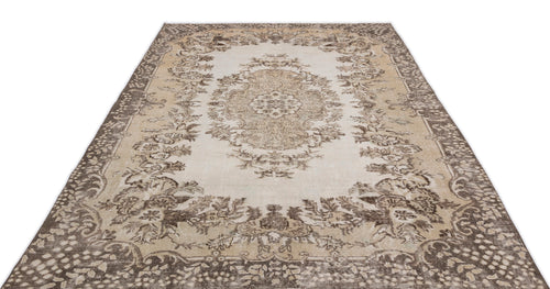 Load image 1 in gallery view. The Hakeon Vintage Medallion Rug (6'5" x 9'8") features intricate floral and vine patterns in beige, brown, and cream with a large medallion and ornate border. Shown photographed on a white background.