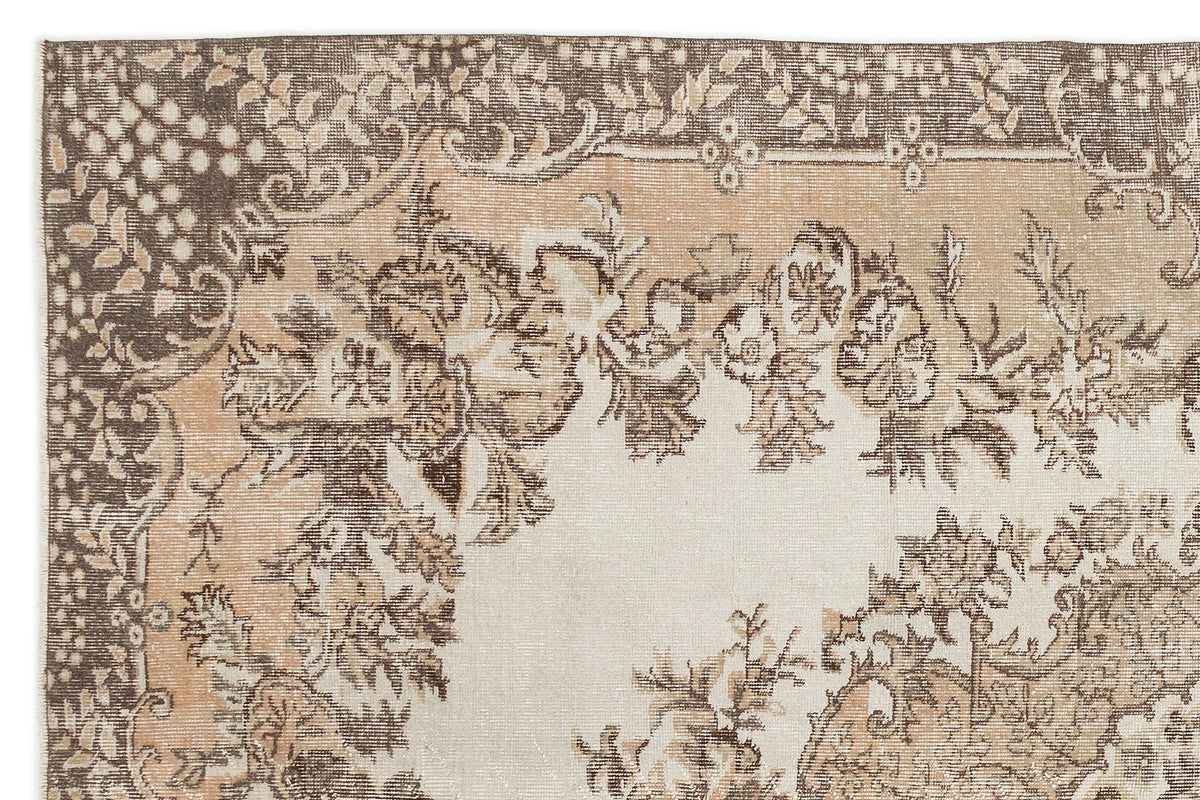 The Hakeon Vintage Medallion Rug (6'5" x 9'8") features a faded floral and ornate medallion pattern in beige, brown, and tan, with intricate borders and distressed details for an authentic antique look.