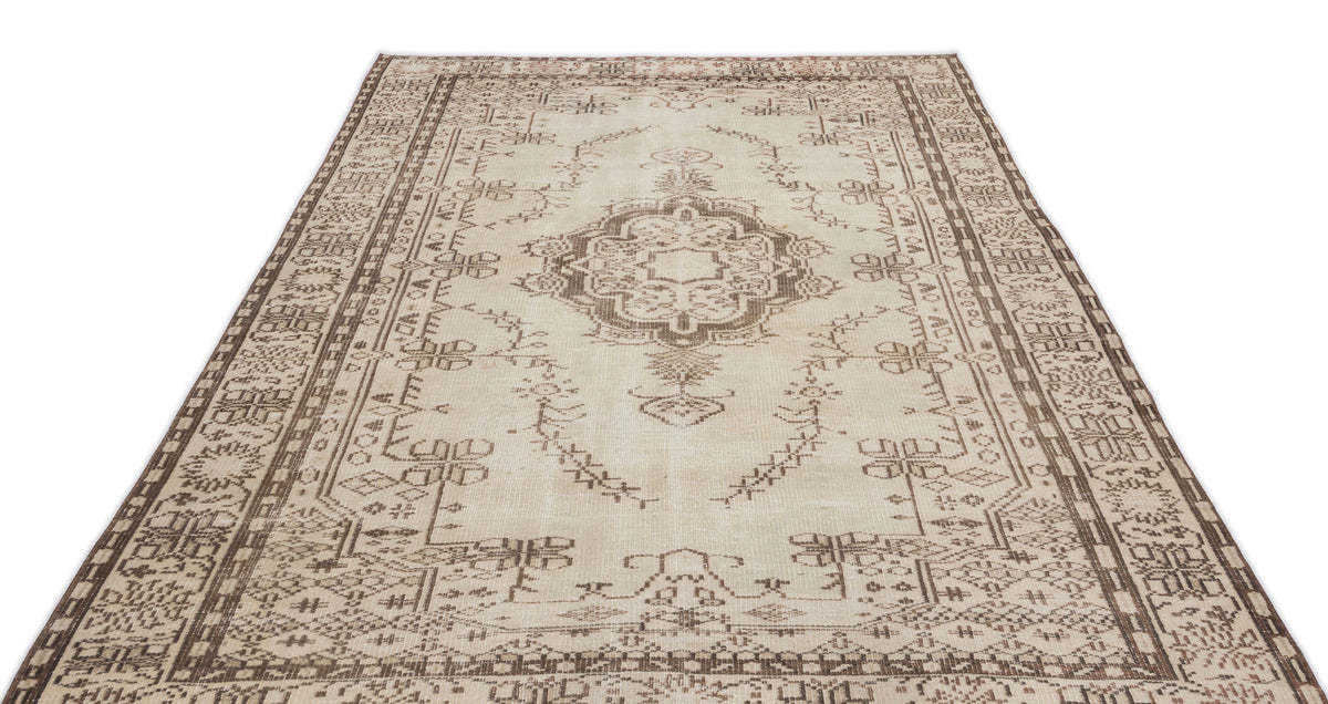The Kidaen - Vintage Medallion Rug (6'0 x 9'6) features a beige and brown Anatolian hand-woven design with an ornate central medallion, geometric borders, and intricate symmetrical patterns. Displayed on a white background.