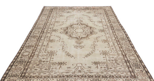 Load image 1 in gallery view. The Kidaen - Vintage Medallion Rug (6'0 x 9'6) features a beige and brown Anatolian hand-woven design with an ornate central medallion, geometric borders, and intricate symmetrical patterns. Displayed on a white background.