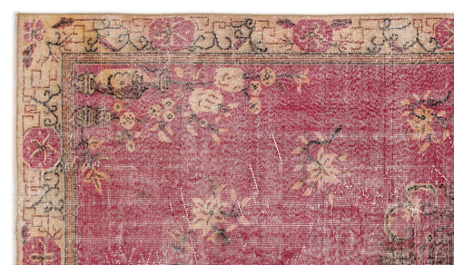 Load image 1 in gallery view. Distressed magenta rug with a beige floral border and scattered cream blossom motifs.