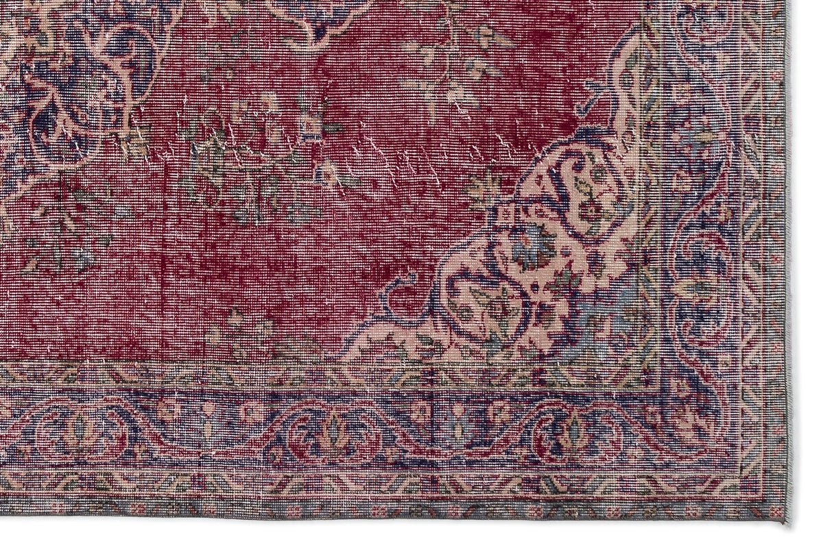 Deep red traditional rug with a distressed floral medallion pattern, cream accents, and a dark blue ornate border.