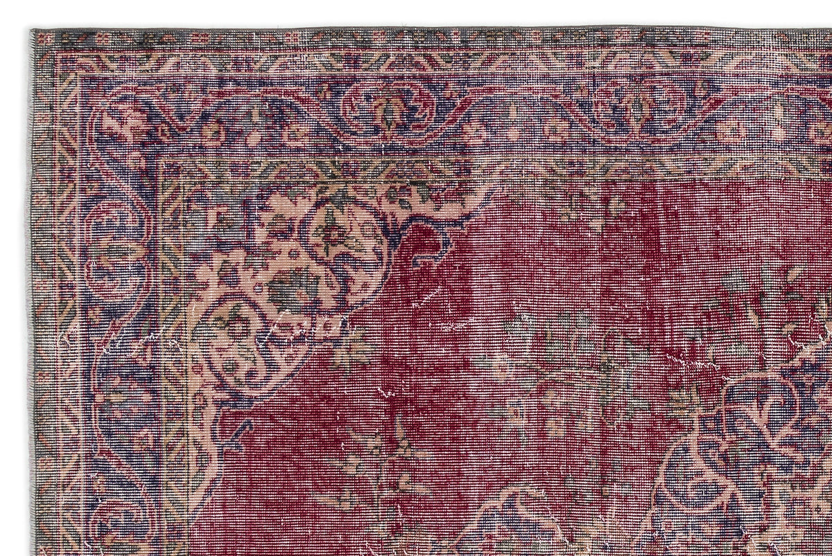 Distressed red, blue, and cream traditional rug with an ornate floral medallion border and faded central pattern.
